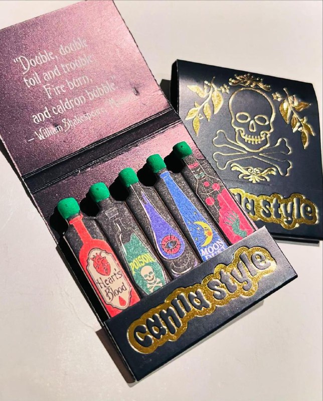 Набор спичек в коробке с чёрной обложкой и золотистым тиснением, внутри цветные наконечники и изображение черепа — дерзкий ретро‑дизайн упаковки для коллекционеров.