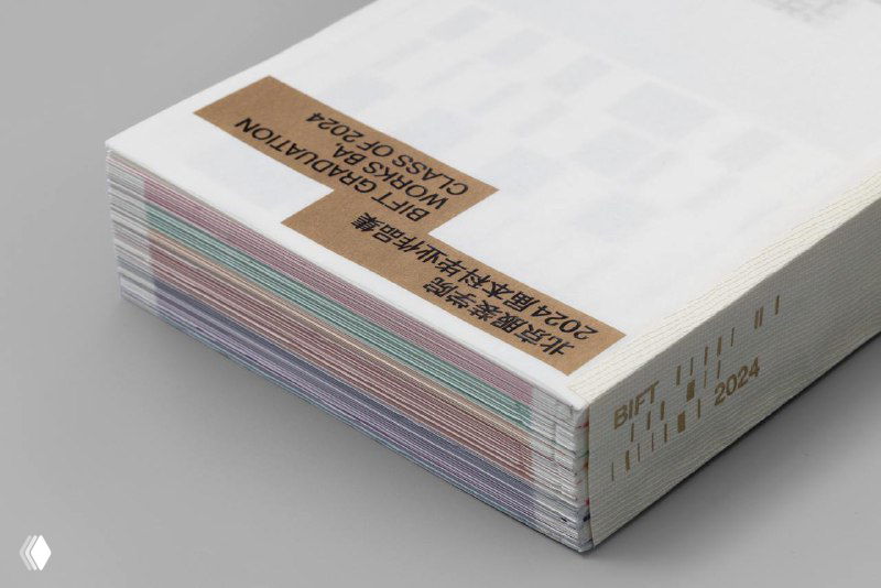 Стопка каталогов «Ritornello»: видны торцы с цветными слоями бумаги и наклеенная коричневая этикетка с текстом, демонстрирующая переплёт и типографию проекта