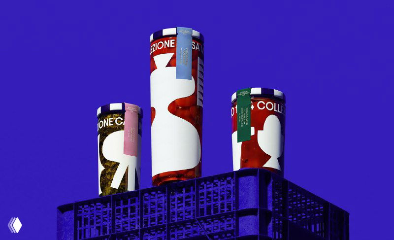 Три банки консервов Casa Marrazzo 1934 на синем фоне; композиция подчёркивает форму туб и масштаб графики на упаковке.