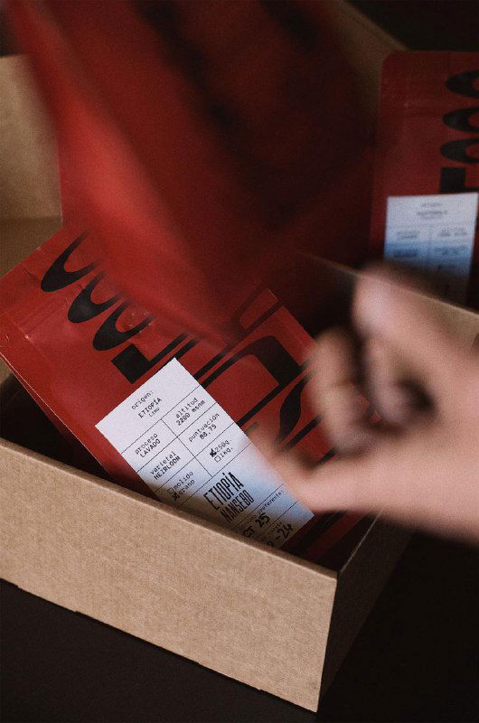 Крупный план красной упаковки Mospresso с наклейкой; виден яркий шрифт, утилитарная вёрстка информационной этикетки и текстурная поверхность пакета.