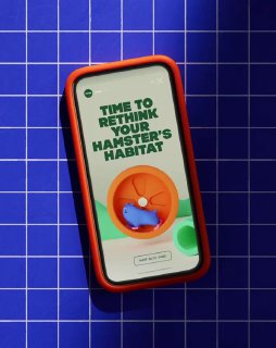 Мокап мобильного интерфейса с надписью «TIME TO RETHINK YOUR HAMSTER'S HABITAT» на синей решётчатой подложке, игривый дизайн для товаров мелких животных