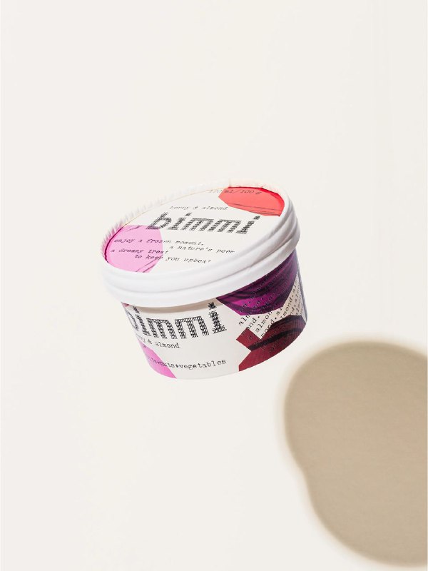 Один пластиковый контейнер Bimmi на светлом фоне с яркой цветной этикеткой и мягкой тенью, крупный план логотипа и фактуры наклейки, минималистичная композиция.