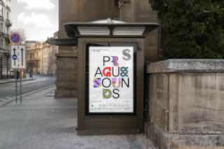 Уличный рекламный стенд с плакатом 'Prague Sounds': цветные декоративные буквы на белом фоне в городском окружении и уличном контексте.