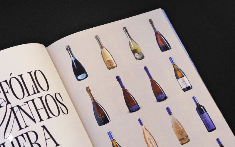 Разворот журнала с иллюстрациями винных бутылок и крупной типографикой; страницы оформлены в светлой палитре с чёткой вёрсткой.