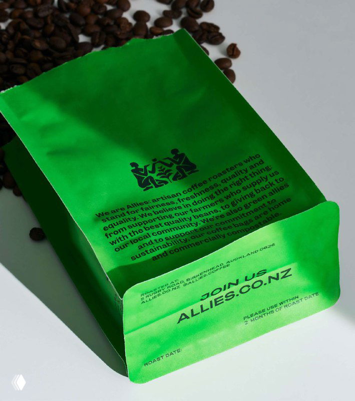 Крупный план задней стороны зелёного пакета Allies с мелким печатным текстом и просыпающимися зёрнами в кадре.