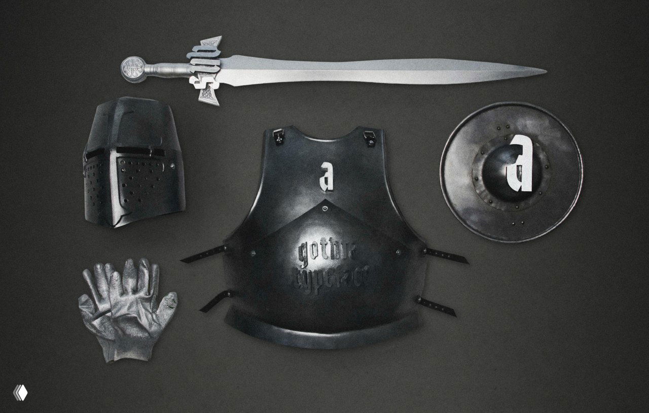 Набор реквизита: шлем, панцирь, щит с литерой и перчатка, выложенные на тёмном фоне как атрибуты визуальной концепции шрифта.
