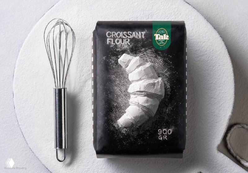 Упаковка Tak с иллюстрацией круассана, рядом металлическая веничка; визуализация концепта 'из муки' в упаковке и рекламе, Backbone Branding.