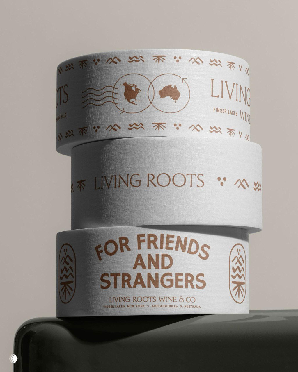 Стеклянные цилиндрические коробки и упаковка с печатью Living Roots и надписью «FOR FRIENDS AND STRANGERS» — примеры фирменной графики и типографии.