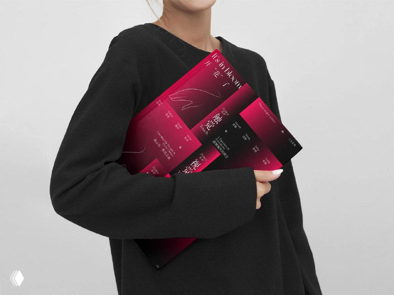 Модель в тёмной одежде держит в руках несколько пурпурно-розовых постеров CB DESIGN, демонстрация печатного варианта макета в реальном использовании.