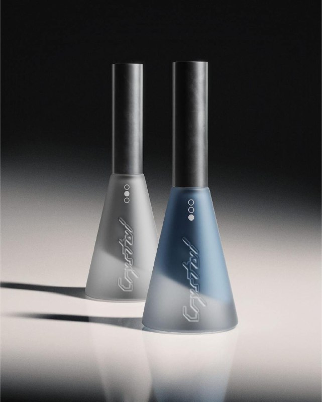 Два флакона лака из серии Crystal на нейтральном фоне: матовые поверхности, минималистичные формы и фирменный силуэт.