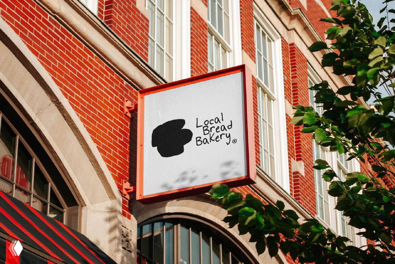 Вывеска пекарни на фасаде: минималистичный логотип в чёрном на белом фоне, пример применения айдентики в реальном окружении магазина.