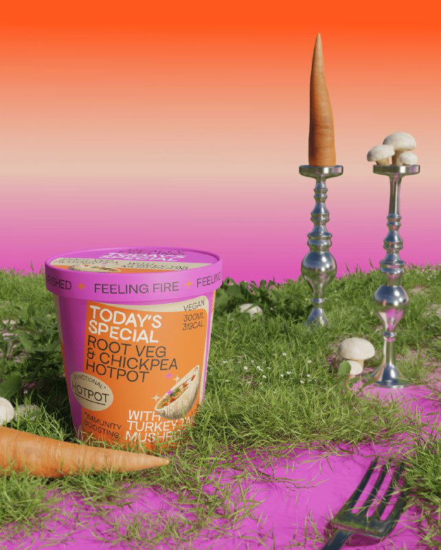 Крупный кадр упаковки на ярком градиенте: стаканчик с этикеткой, рядом морковь и грибы на травяной подложке, современный дизайн этикетки.