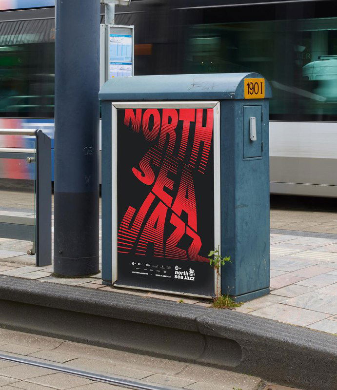Уличный плакат с красной кинетической типографикой North Sea Jazz на городской стойке, пример применения динамической айдентики в городской среде.
