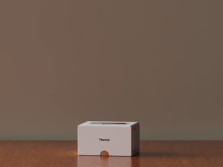 Фоторендер упаковки Therma на столе: белая коробка, фирменный штрих и спокойная бежево-коричневая палитра, подчёркивающая домашнюю атмосферу.