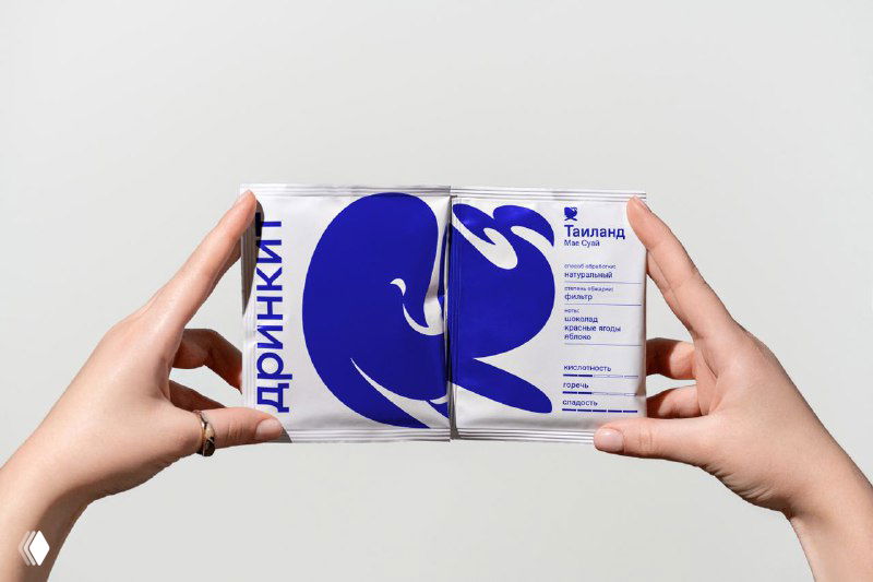 Упаковка или коробка с крупным синим логотипом‑эмоджи и надписью дринкит на боковой грани, демонстрация модульного логотипа в брандинге.