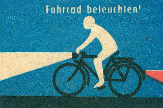 Ретро-иллюстрация велосипедиста на синем фоне с яркой фарой: графическая этикетка спичечного коробка в минималистичном стиле дорожной пропаганды