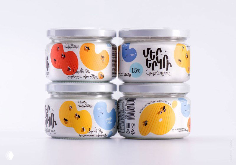 Стеклянные и алюминиевые тубы Mer Yerkir в стопке: студийная съёмка показывает текстуру упаковки и принты на поверхности.