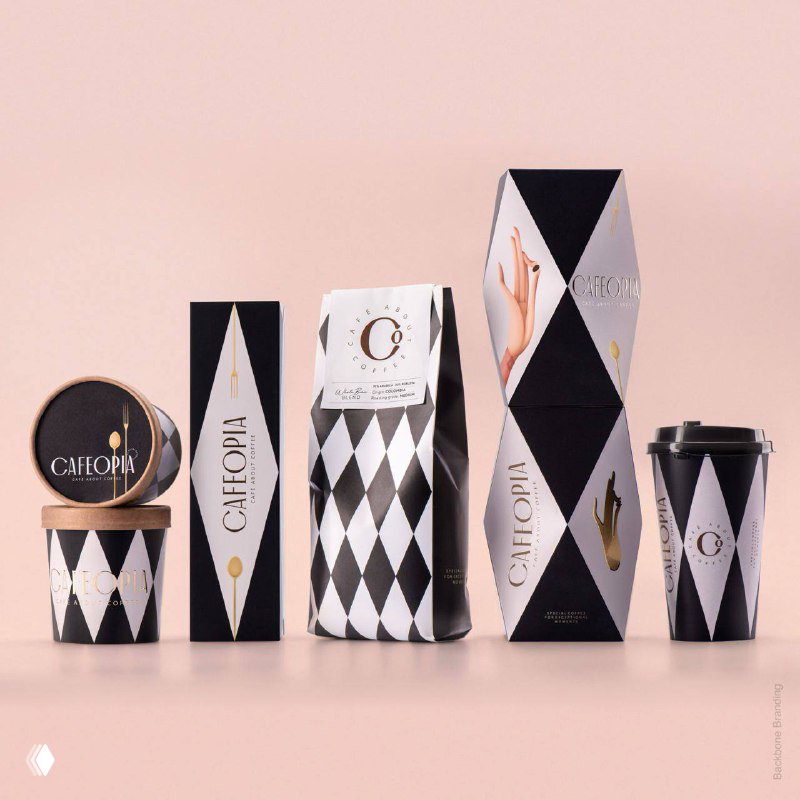 Коллекция упаковки Cafeopia в геометрических черно‑белых и пастельных решениях: стаканы, коробки и пакеты с характерными иллюстрациями рук.