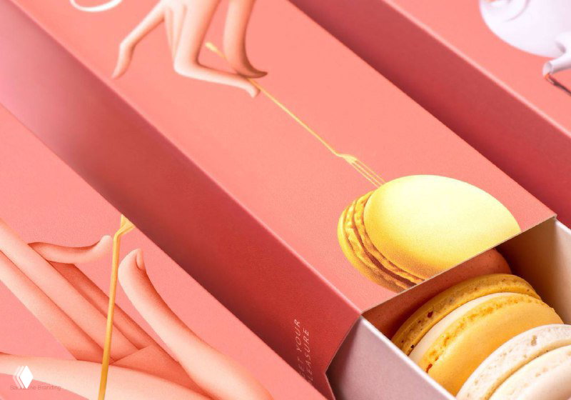 Макароны в красочной коробочке Cafeopia: детальный кадр показывает нанесённую иллюстрацию руки и золотую линию, отсылающую к ар‑деко мотивам бренда.