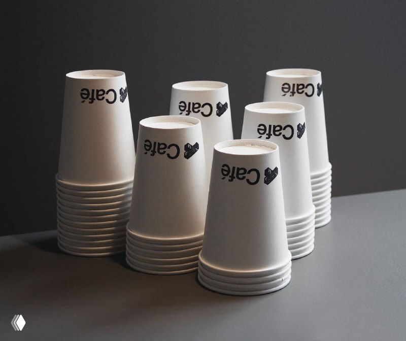 Стопка бумажных стаканчиков для кафе с повторяющимся лаконичным логотипом — пример применения айдентики в F&B зонах музея и кафе.