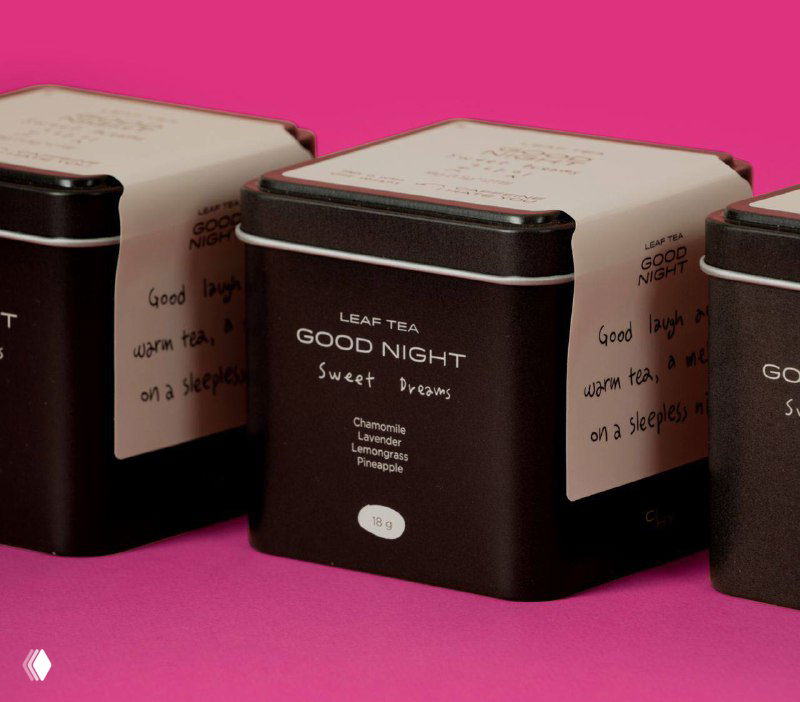 Чёрные и белые коробки CIHY в ряду на розовом фоне, крупный план ряда упаковок с читаемыми этикетками и контрастной типографикой. Фото проекта на Behance.