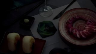 Крупный план сервировки: посуда и подставка из зелёной полупрозрачной смолы рядом с тарелкой и бокалом в интерьере AOAO.