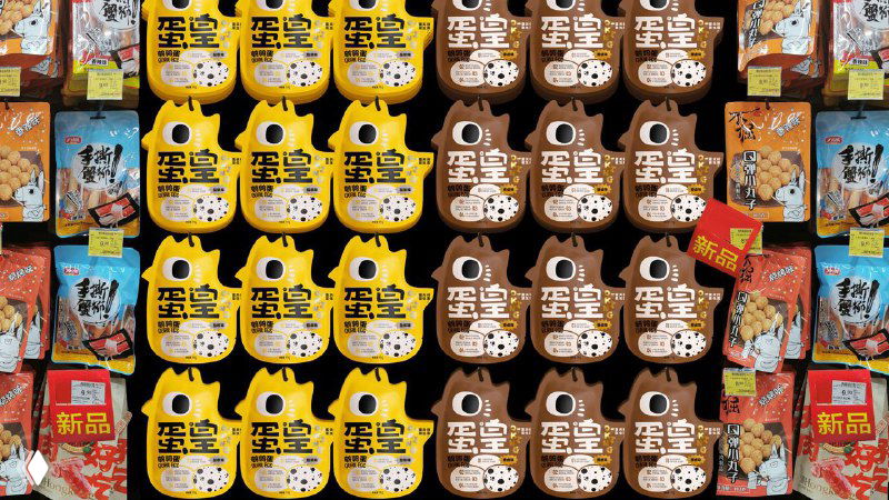 Стеллаж или дисплей с множеством упаковок продукта: оформление торговой выкладки и повторяемость дизайна в рознице.