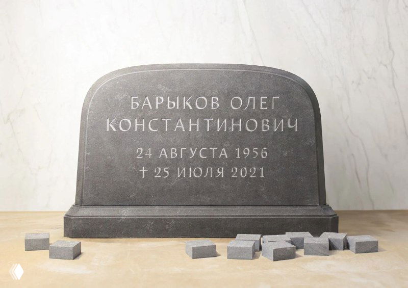 Чёрно-серое широкое надгробие из гранита с чёткой белой гравировкой; на переднем плане — небольшие квадратные шлифовочные элементы, рабочая студия.