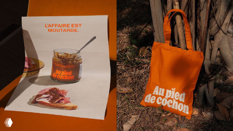 Промоматериалы и оранжевая сумка с логотипом Au Pied de Cochon: применение брендинга на печатных материалах и мерче.