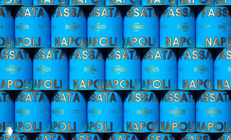 Стек синих банок Casa Marrazzo, повторяющаяся золотая типографика на насыщенном синем фоне; фотография подчёркивает ритм и графику упаковки бренда.