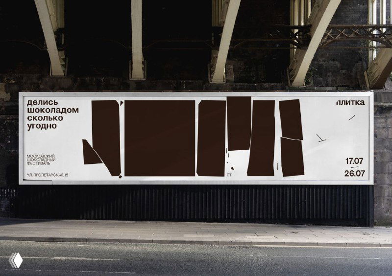 Широкий уличный баннер с рядом коричневых прямоугольных фрагментов, расположенных как ряд плиток, на белом фоне под мостом или в переходе.