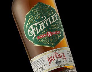 Крупная часть бутылки виски с зелёной ромбовидной этикеткой и декоративной типографикой; пример винтажной упаковки и композиции как референс для дизайна.