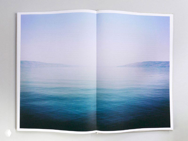 Разворот фотокниги с тихим морским пейзажем: пастельные тона неба и воды при двухстраничном развороте без текста.