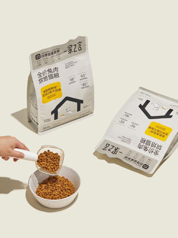 Две упаковки и порция корма: белые пакеты на нейтральном фоне, одна упаковка лежит, другая стоит, демонстрируется масштаб и текстура брендинга