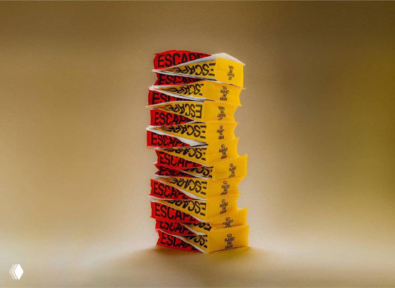 Стек упаковок Escape в студийной съёмке: жёлто‑красные коробки с логотипом, аккуратная укладка и нейтральный фон для демонстрации пакетов.