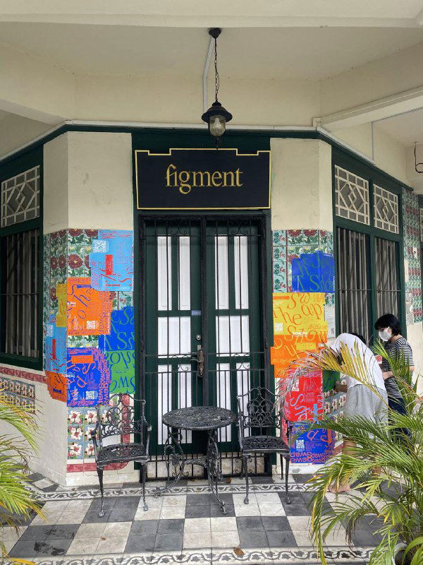 Фасад кафе или галереи, украшенный яркими постерами The Swap Show и мозаичными цветными заплатами на стене, уличный контекст проекта.