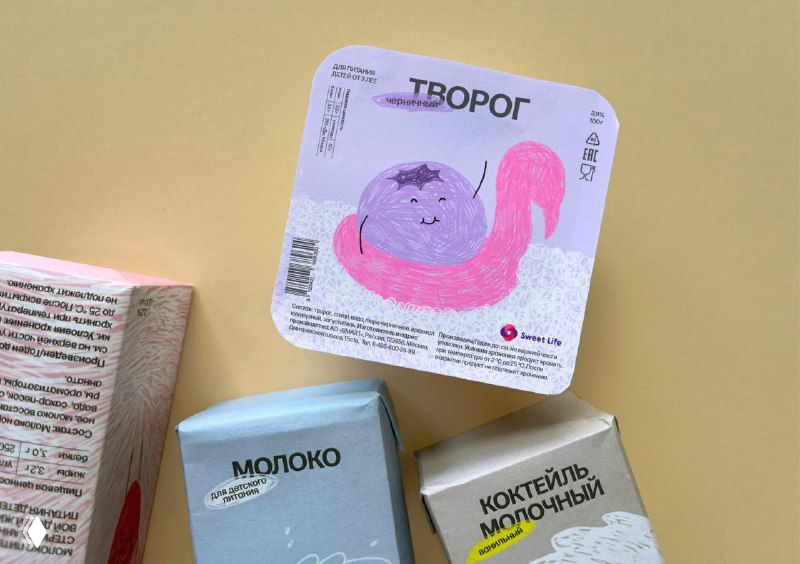 Крупный план этикеток творога и молочных коктейлей с разнообразными детскими иллюстрациями и нежной палитрой на упаковке.