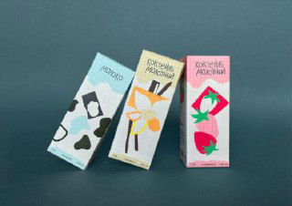 Три картонные пачки молочных коктейлей в ряд: разнообразие этикеток с цветочными и фруктовыми мотивами в детской стилистике.