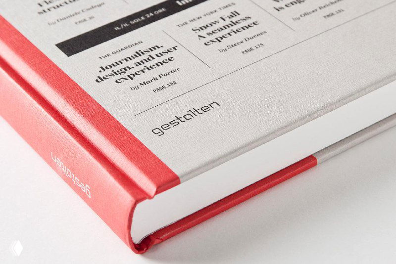 Крупный план торца и внутренней окантовки переплёта книги «Designing News» — текстура обложки и аккуратный книжный блок.