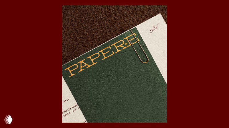 Фрагмент фирменной канцелярии: тёмно‑зелёная обложка с золотым тиснением PAPERE, видна текстура бумаги и аккуратная полиграфическая обработка.