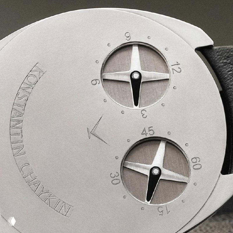 Макрофото задней стороны корпуса Thinking: два круглых индикатора с миниатюрными стрелками, гравировка и матовая серебристая поверхность корпуса.