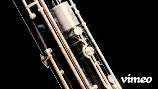 Детализация клавиш и трубок инструмента крупным планом; стеклянные и металлические осколки летят в пространстве, мрачный фон и световые блики.