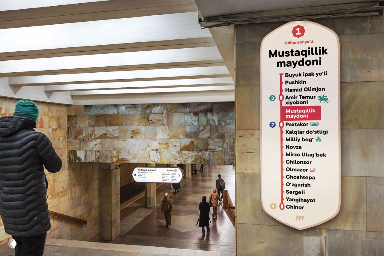 Коридор станции с крупным рекламным щитом «Salom Card» и подвесными навигационными табличками внизу, видна отделка стен и пол.