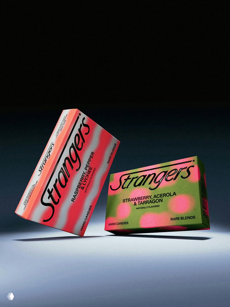 Два наклонённых блока упаковок Strangers на нейтральном фоне; контрастные зелёные и коралловые паттерны и тень от коробок.
