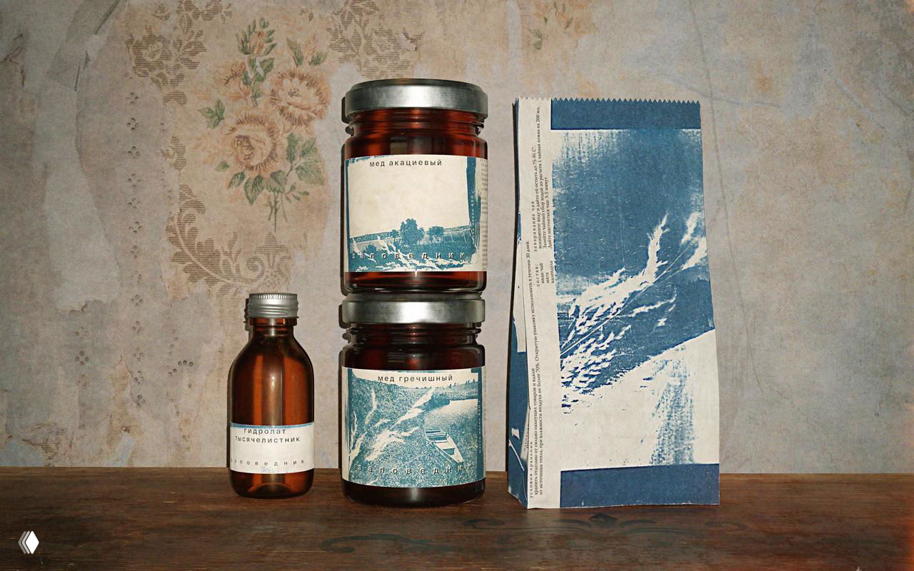 Компоновка из баночек и бумажной упаковки на деревянной поверхности, стилистика минималистичная и природная, подчёркнуты тени и фактура.