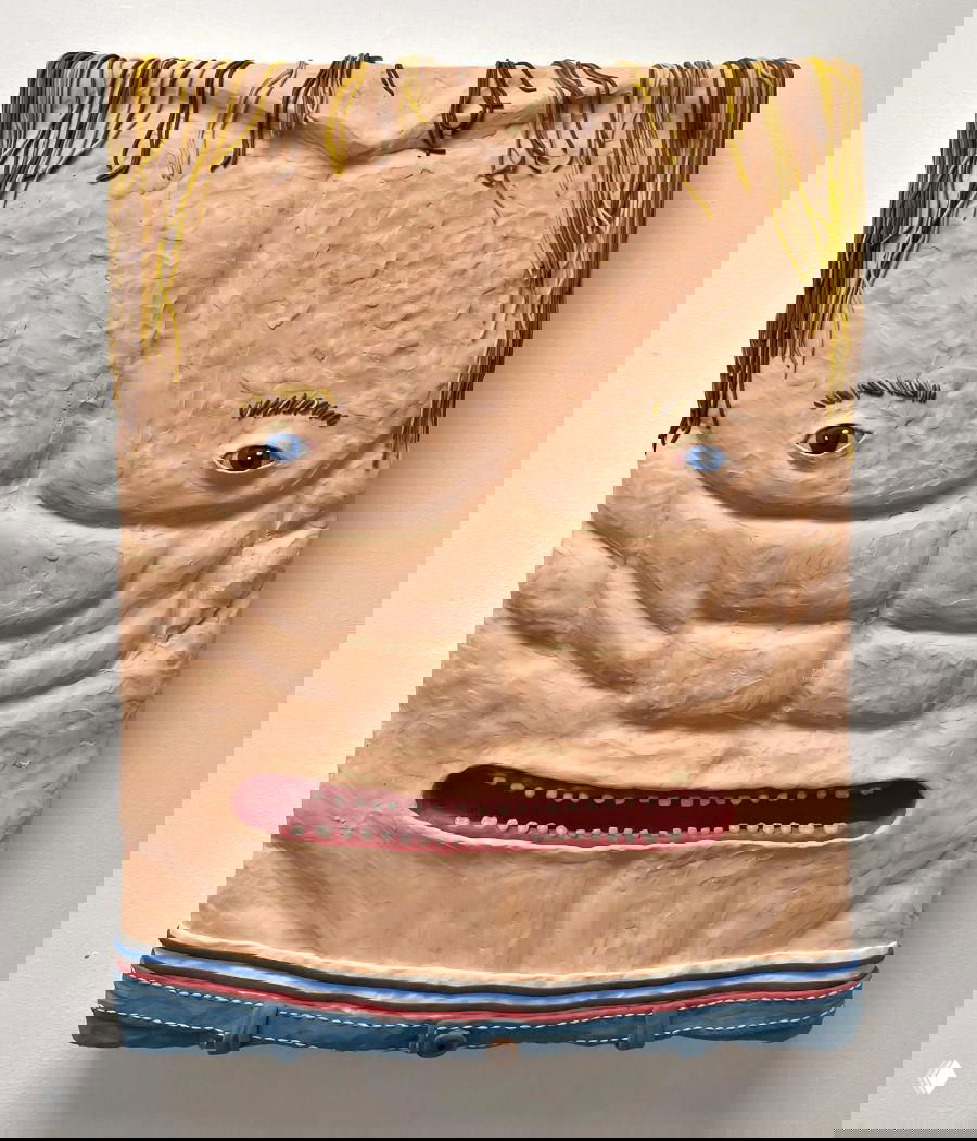 Объёмная пластилиновая панель, изображающая мускулистый торс с глазами и ртом, крупная фактура пластилина и яркая манера исполнения.