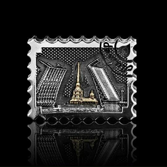 Серебряная подвеска-почтовая марка с изображением разводного моста и собора, золотые акценты и тёмная патина, чёрный отражающий фон, показано крупным планом.