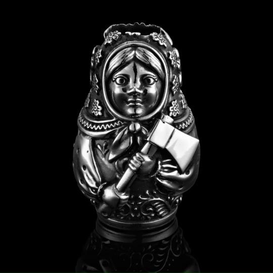 Матрешка-образ с молотком — серебряная подвеска с выразительным лицом, гравировкой и патиной, чёрный отражающий фон, показано крупным планом.