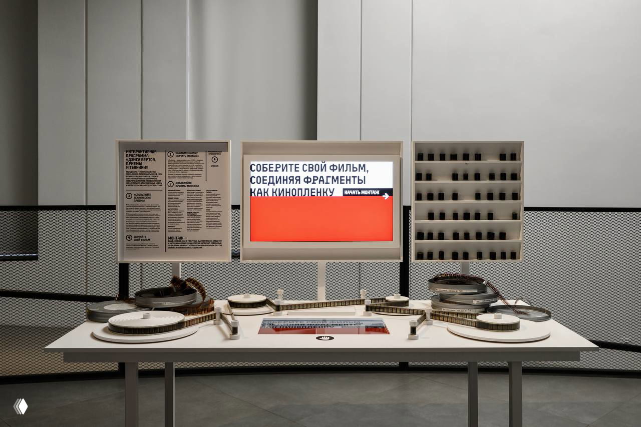 Монтажный стол крупным планом: монитор с надписью «Соберите свой фильм», катушки плёнки и организованные отсеки с фрагментами кадров