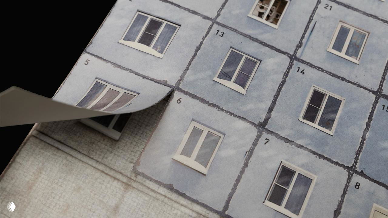 Переплёт и слои страниц календаря: видны страницы в процессе перелистывания, текстура бумаги и печатная фактура изображения фасада